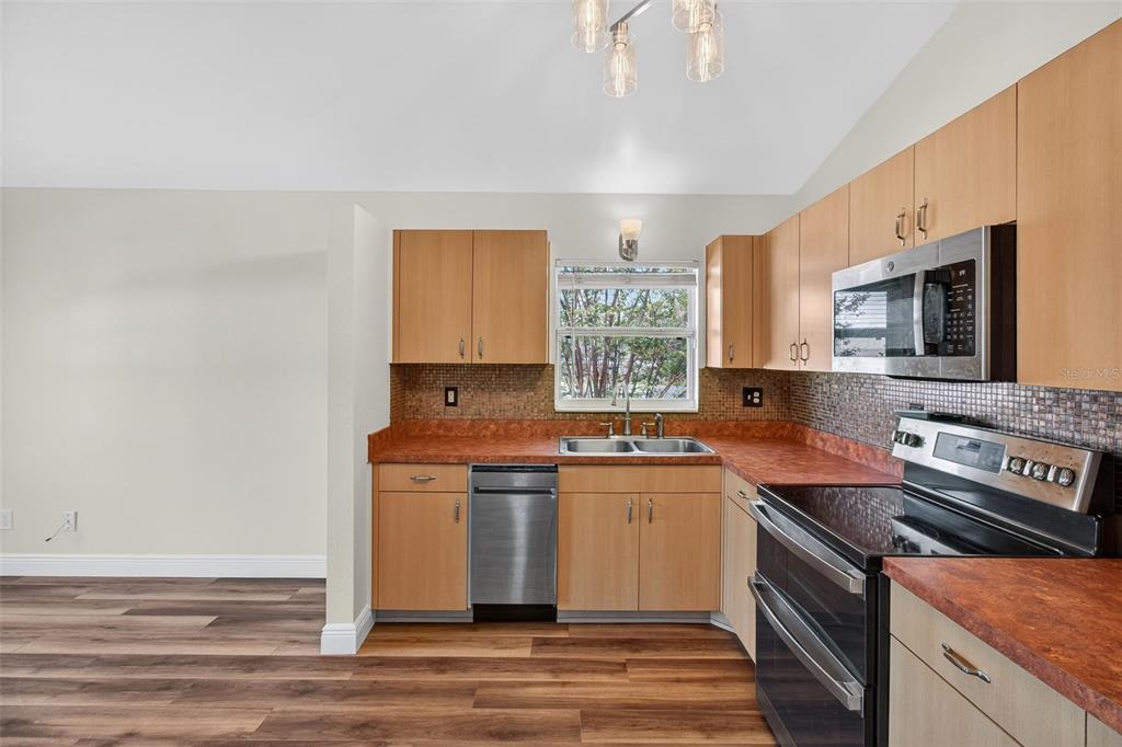 2174 19th Avenue Southwest Largo, FL 33774 - Photo 7 of 31 a kitchen with stainless steel appliances granite countertop a stove a sink and a microwave
