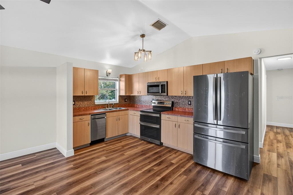 2174 19th Avenue Southwest Largo, FL 33774 - Photo 10 of 31 a kitchen with stainless steel appliances wooden floor sink and a refrigerator