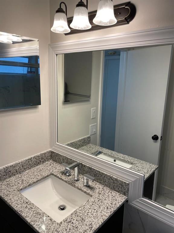 2481 Southwest 82nd Avenue, Unit 101 Davie, FL 33324 - Photo 11 of 14 a bathroom with a granite countertop sink and a mirror