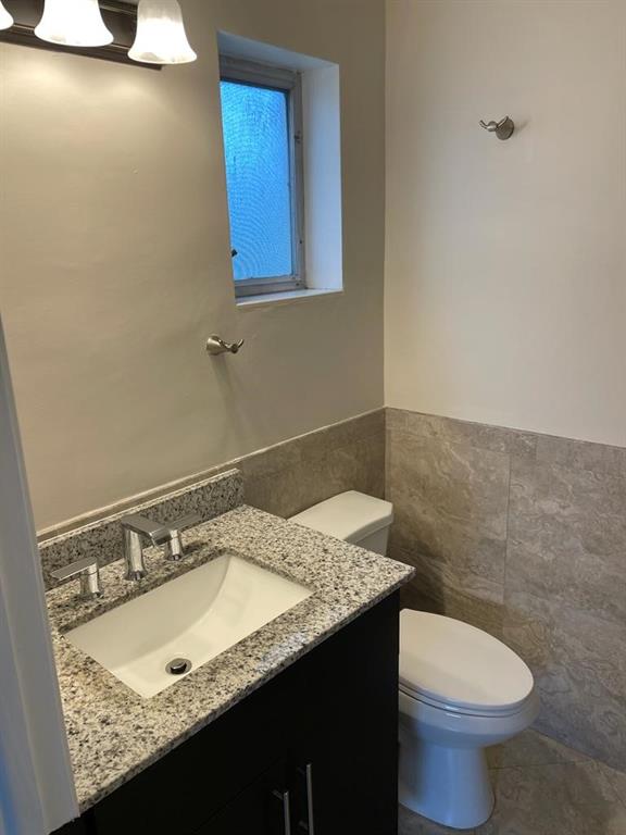2481 Southwest 82nd Avenue, Unit 101 Davie, FL 33324 - Photo 13 of 14 a bathroom with a granite countertop sink and a toilet