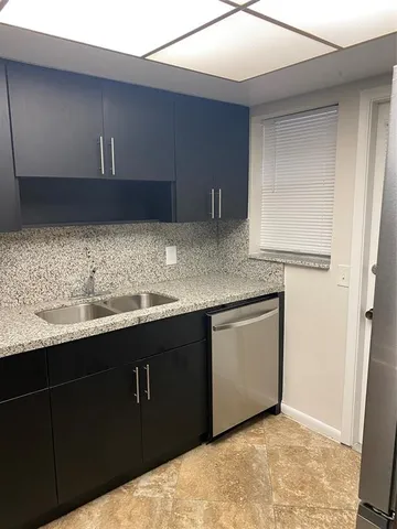 a kitchen with granite countertop a sink a stove and cabinets