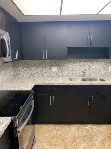 a kitchen with granite countertop a cabinets and steel appliances