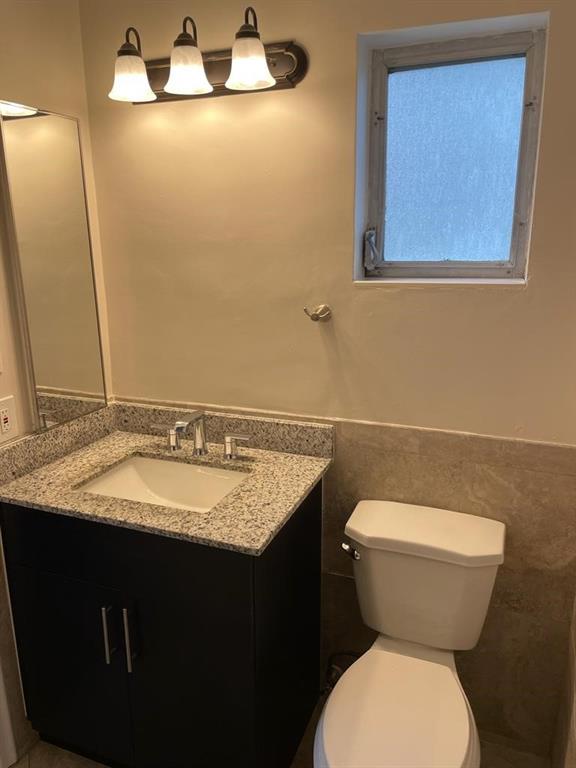 2481 Southwest 82nd Avenue, Unit 101 Davie, FL 33324 - Photo 10 of 14 a bathroom with a granite countertop toilet sink and mirror