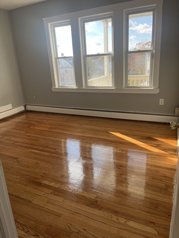 52 Mascot Street, Unit 6 Boston, MA 02124 - Photo 3 of 12 a view of empty room with window and wooden floor
