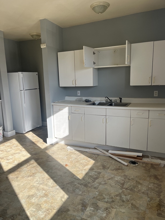 52 Mascot Street, Unit 6 Boston, MA 02124 - Photo 7 of 12 a kitchen with kitchen island sink refrigerator and cabinets