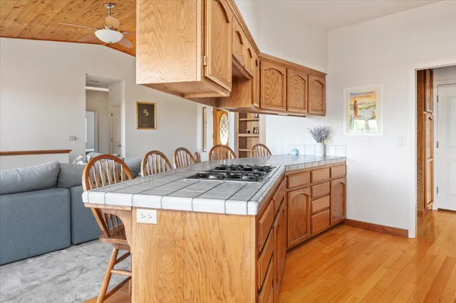 a kitchen with stainless steel appliances granite countertop wooden cabinets a stove a sink and a large window