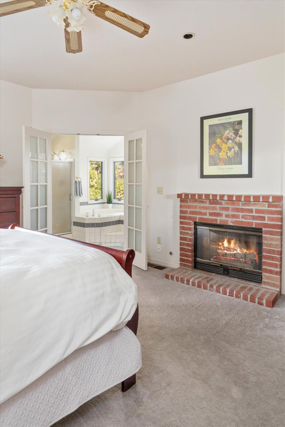 257 Snowberry Court Murphys, CA 95247 - Photo 23 of 56 a spacious bedroom with a bed and a fireplace