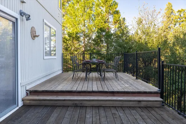 a balcony with wooden floor table and chairs