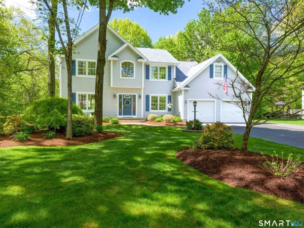 a front view of a house with a yard and trees