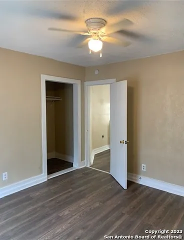a view of empty room with wooden floor
