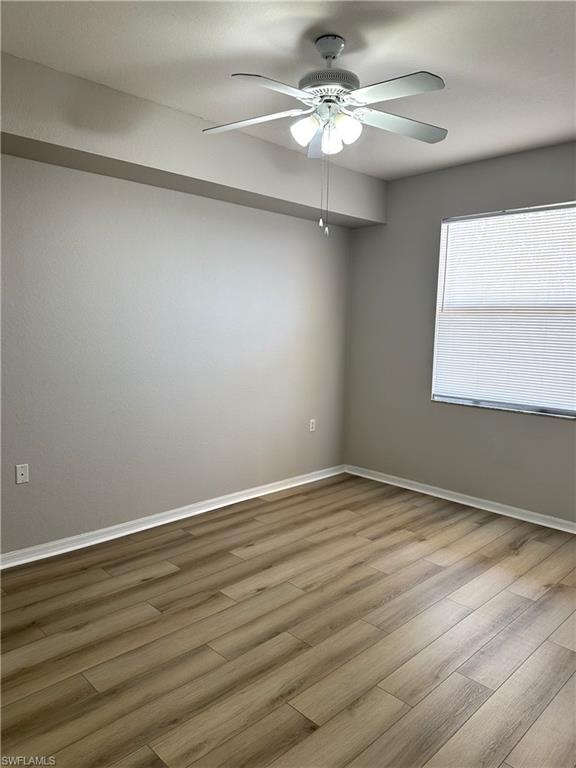 8490 Kingbird Loop, Unit 934 Estero, FL 33967 - Photo 16 of 33 a view of an empty room with wooden floor and a window
