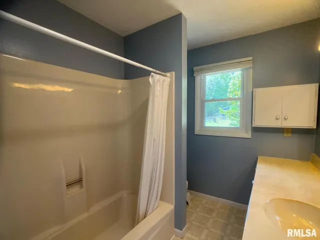 a bathroom with a tub sink and mirror