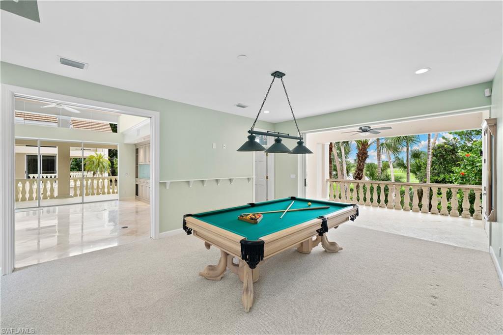 2969 Wulfert Road Sanibel, FL 33957 - Photo 21 of 44 a living room with a table a flat screen tv and a chandelier