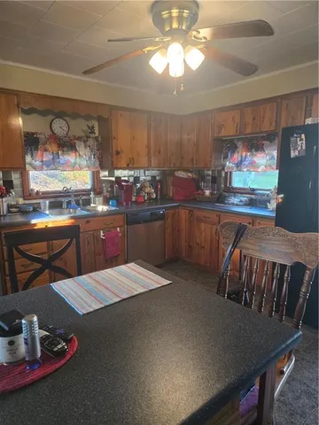 a kitchen with stainless steel appliances kitchen island granite countertop a table chairs stove and cabinets