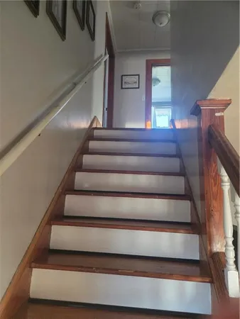 a view of staircase with lots of frames on wall