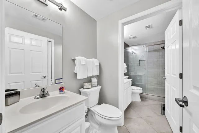 a bathroom with a sink toilet vanity and shower