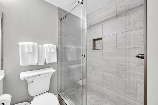 a white toilet sitting next to a bathroom shower