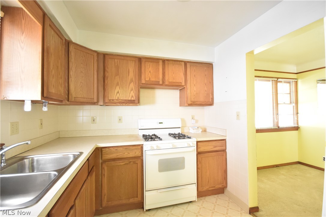 31921 Pendley Road Willowick, OH 44095 - Photo 8 of 22 Kitchen with gas range gas stove, light colored carpet, sink, and backsplash