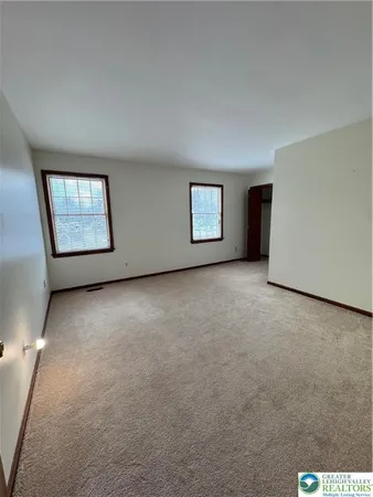 an empty room with windows and closet