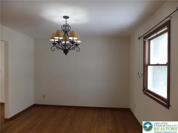 a view of a chandelier in big room and wooden floor
