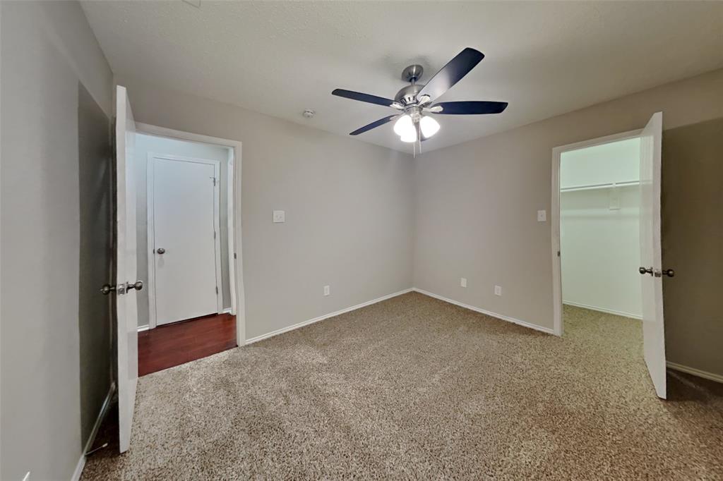 8404 Trinity Vista Trail Fort Worth, TX 76053 - Photo 11 of 18 Unfurnished bedroom with a walk in closet, light colored carpet, and ceiling fan