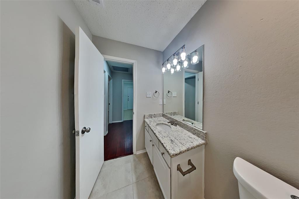 8404 Trinity Vista Trail Fort Worth, TX 76053 - Photo 15 of 18 Bathroom with vanity, light tile patterned floors, and a textured ceiling