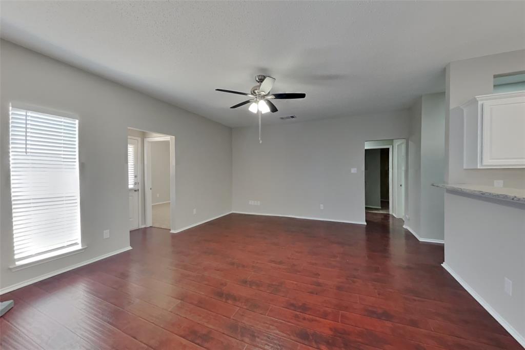 8404 Trinity Vista Trail Fort Worth, TX 76053 - Photo 3 of 18 Unfurnished living room featuring dark wood-type flooring and a ceiling fan