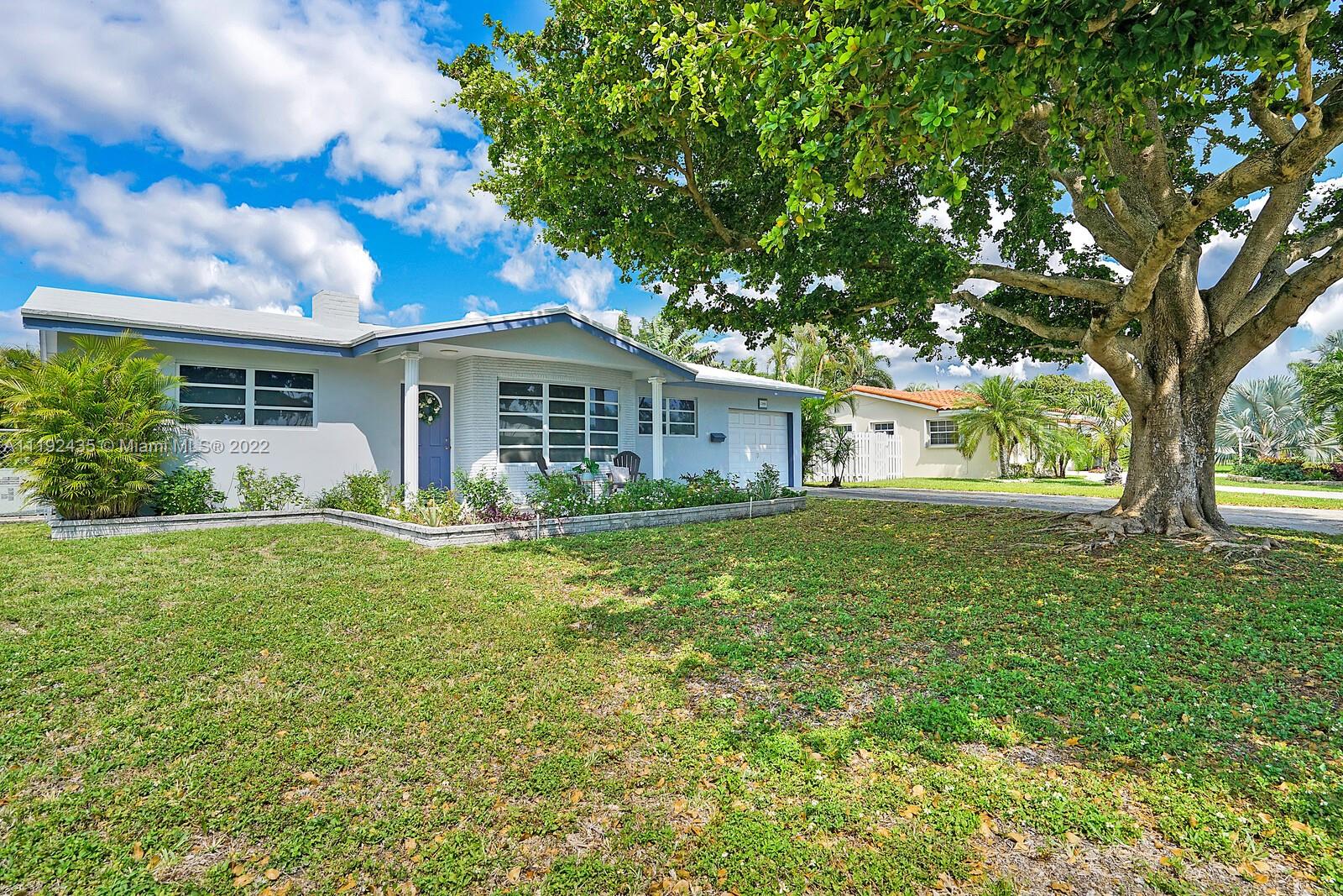 5211 Northeast 26th Avenue Lighthouse Point, FL 33064 - Photo 2 of 43 a front view of house with yard and green space