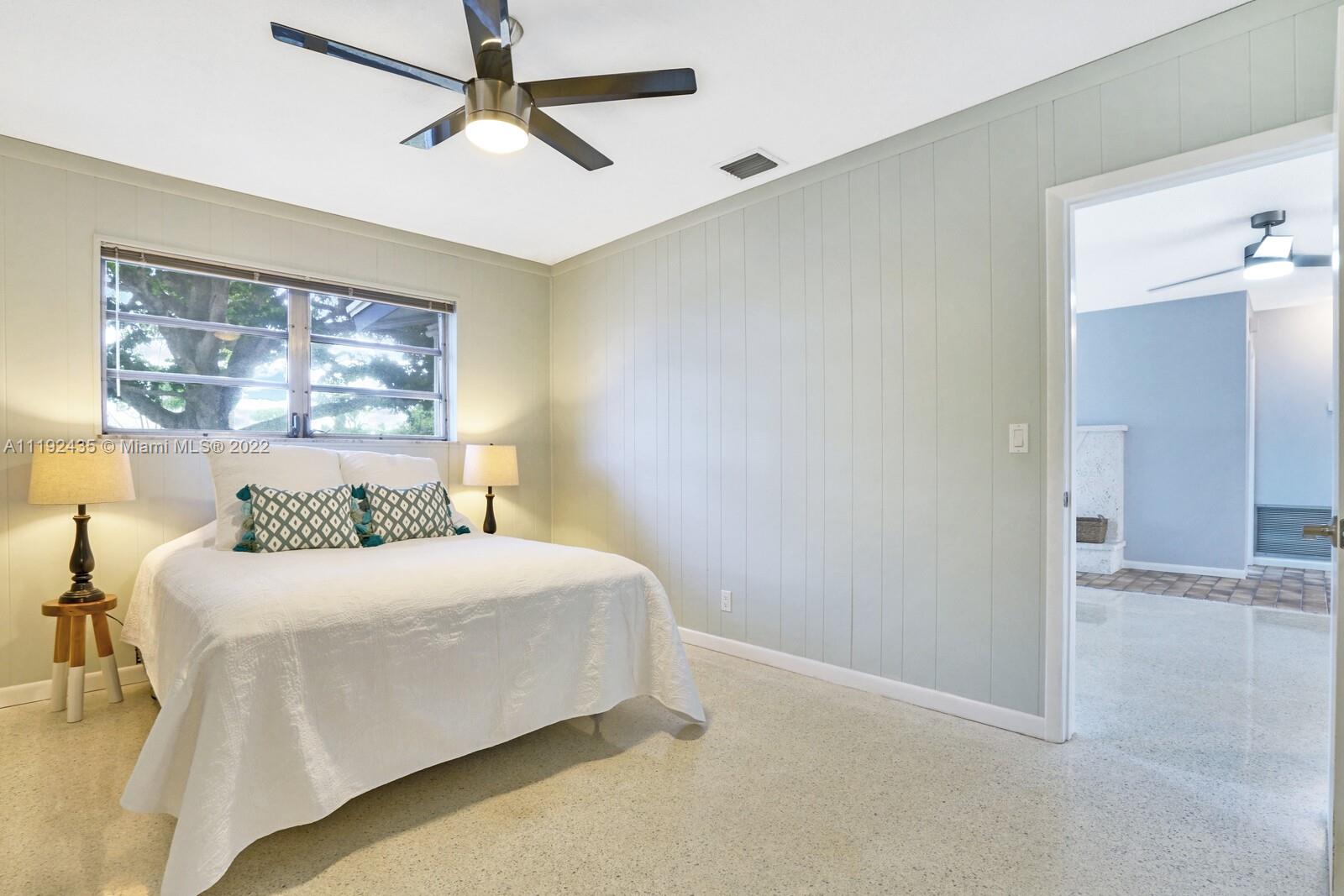5211 Northeast 26th Avenue Lighthouse Point, FL 33064 - Photo 30 of 43 a bedroom with a large bed and a chandelier
