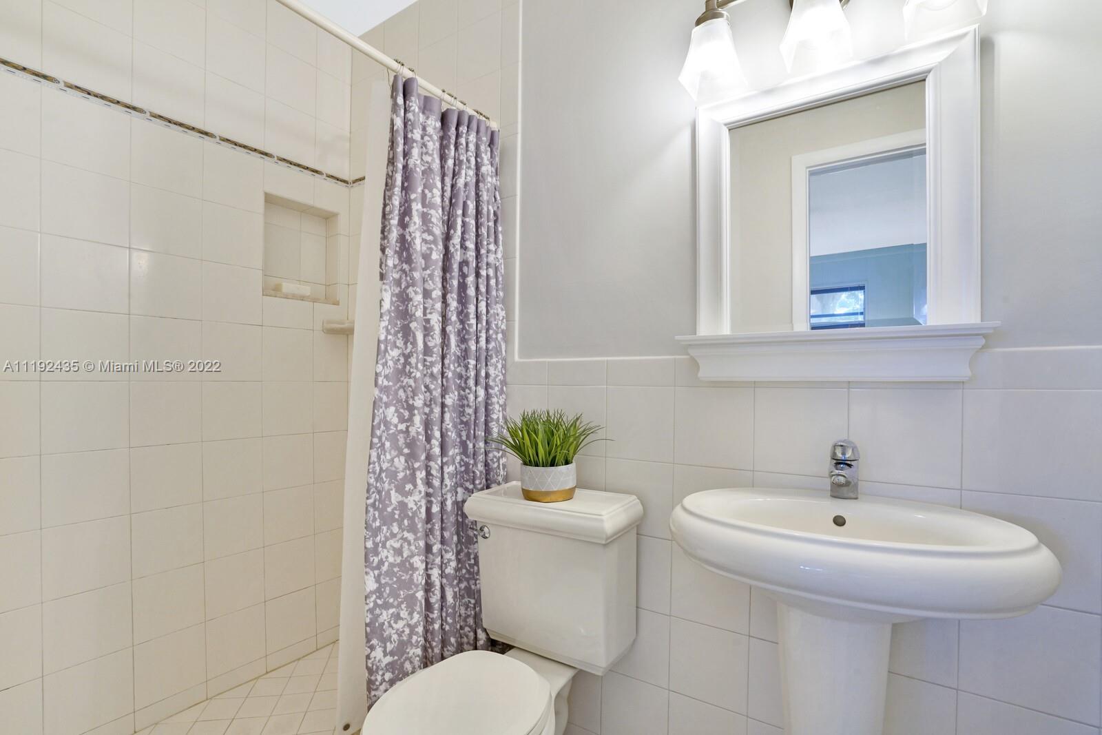 5211 Northeast 26th Avenue Lighthouse Point, FL 33064 - Photo 39 of 43 a bathroom with a sink toilet and a mirror
