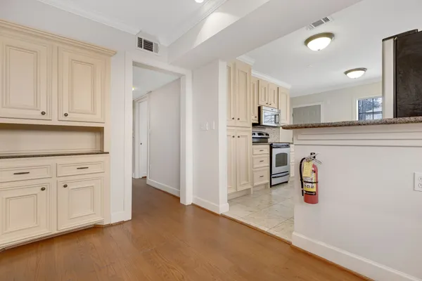 a kitchen with white cabinets and stainless steel appliances