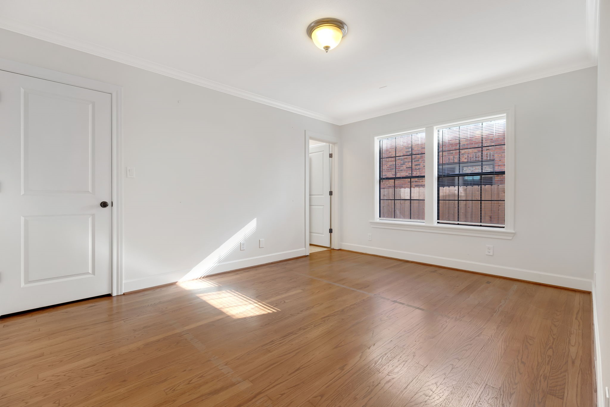 2306 Blodgett Street, Unit 1 Houston, TX 77004 - Photo 8 of 11 an empty room with wooden floor and windows