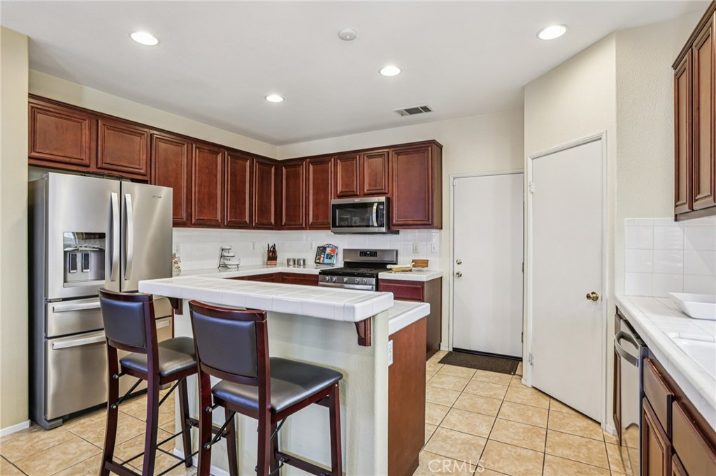 17550 Buttonwood Lane Carson, CA 90746 - Photo 12 of 43 a kitchen with stainless steel appliances a stove a sink refrigerator and a microwave