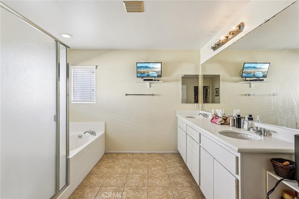 17550 Buttonwood Lane Carson, CA 90746 - Photo 17 of 43 a bathroom with a double vanity sink a mirror and a bathtub
