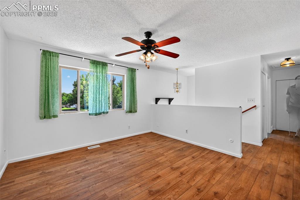 305 Iris Drive Fountain, CO 80817 - Photo 3 of 22 a view of a livingroom with wooden floor a ceiling fan and windows