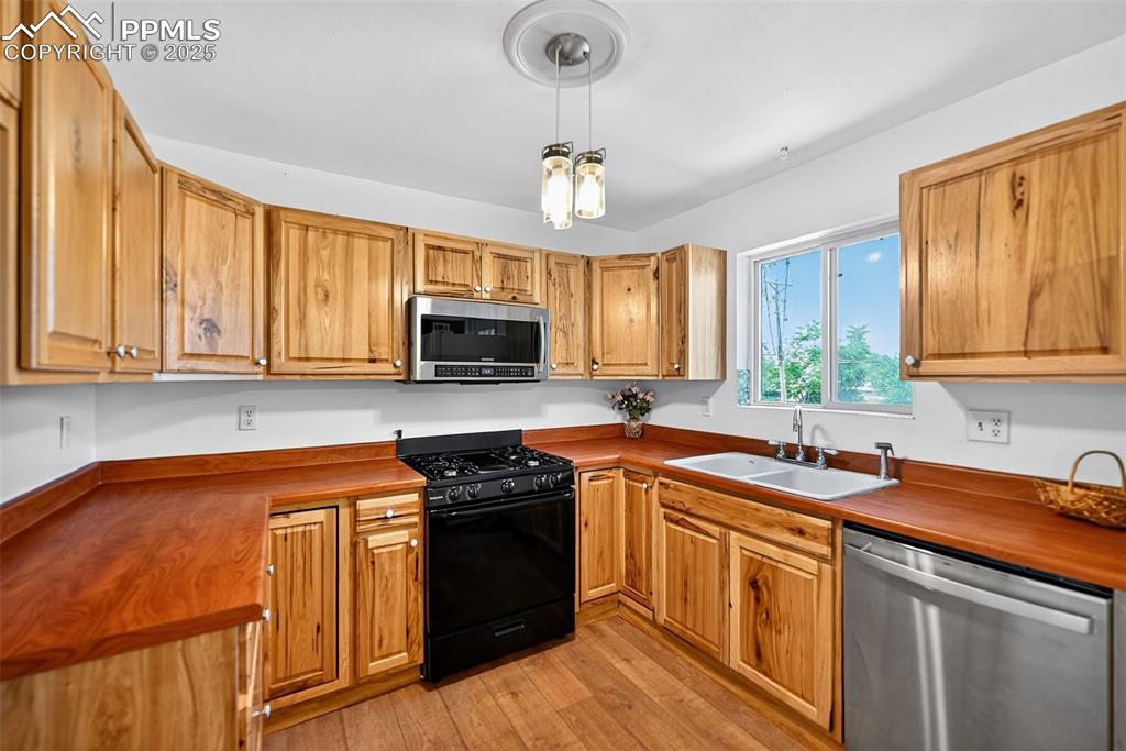 305 Iris Drive Fountain, CO 80817 - Photo 6 of 22 a kitchen with stainless steel appliances granite countertop a sink stove and microwave