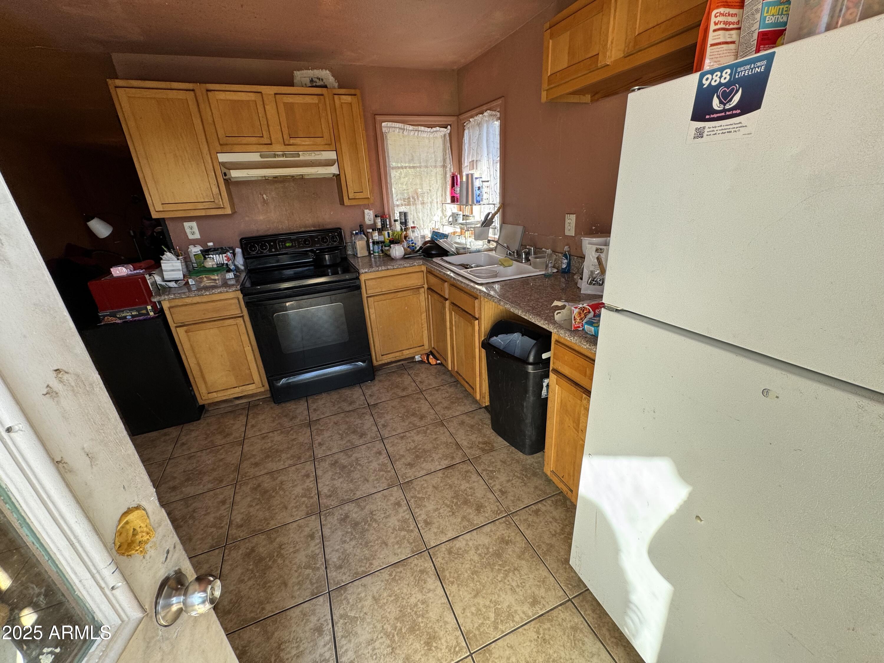 2425 West Papago Street Phoenix, AZ 85009 - Photo 2 of 16 a kitchen with a sink a stove top oven a counter space and cabinets