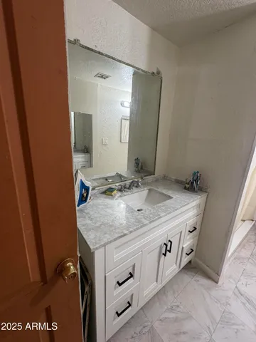 a bathroom with a granite countertop sink and a mirror