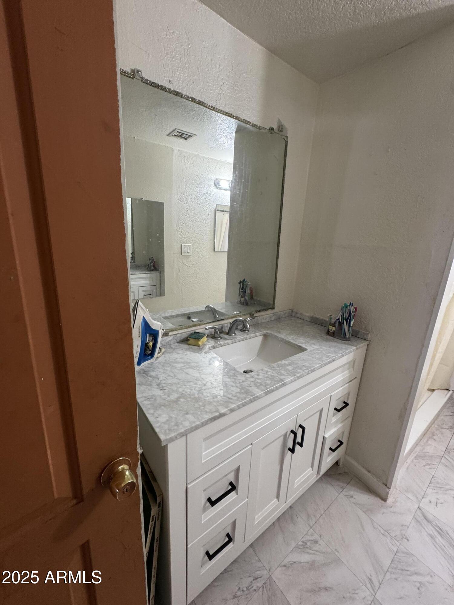 2425 West Papago Street Phoenix, AZ 85009 - Photo 5 of 16 a bathroom with a granite countertop sink and a mirror