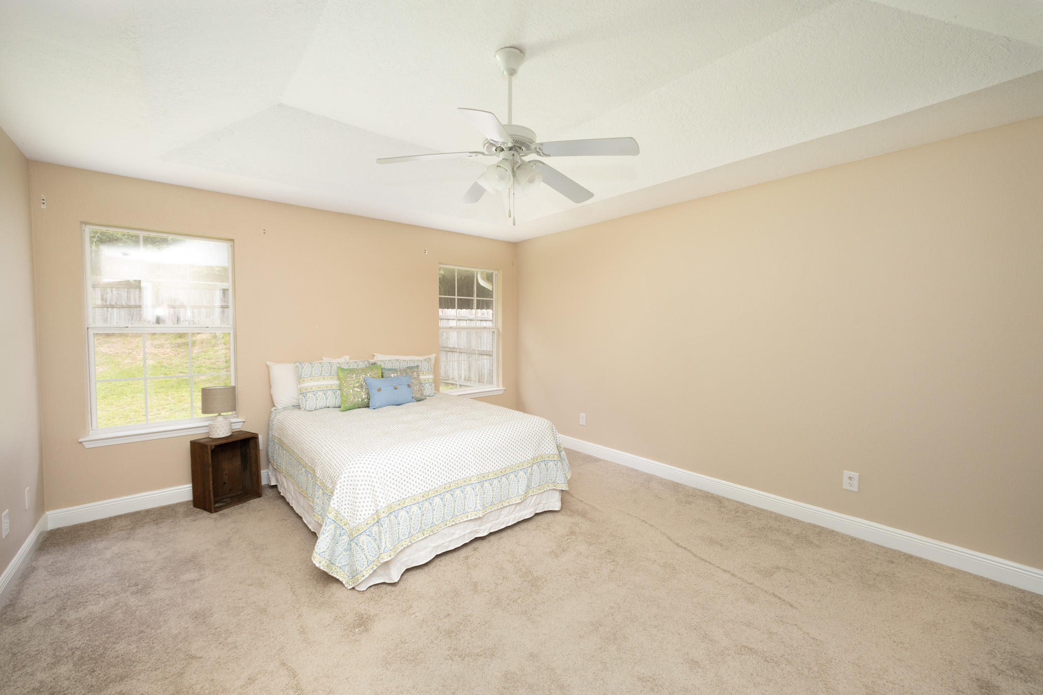653 Territory Lane Crestview, FL 32536 - Photo 14 of 29 a spacious bedroom with a bed and a chandelier