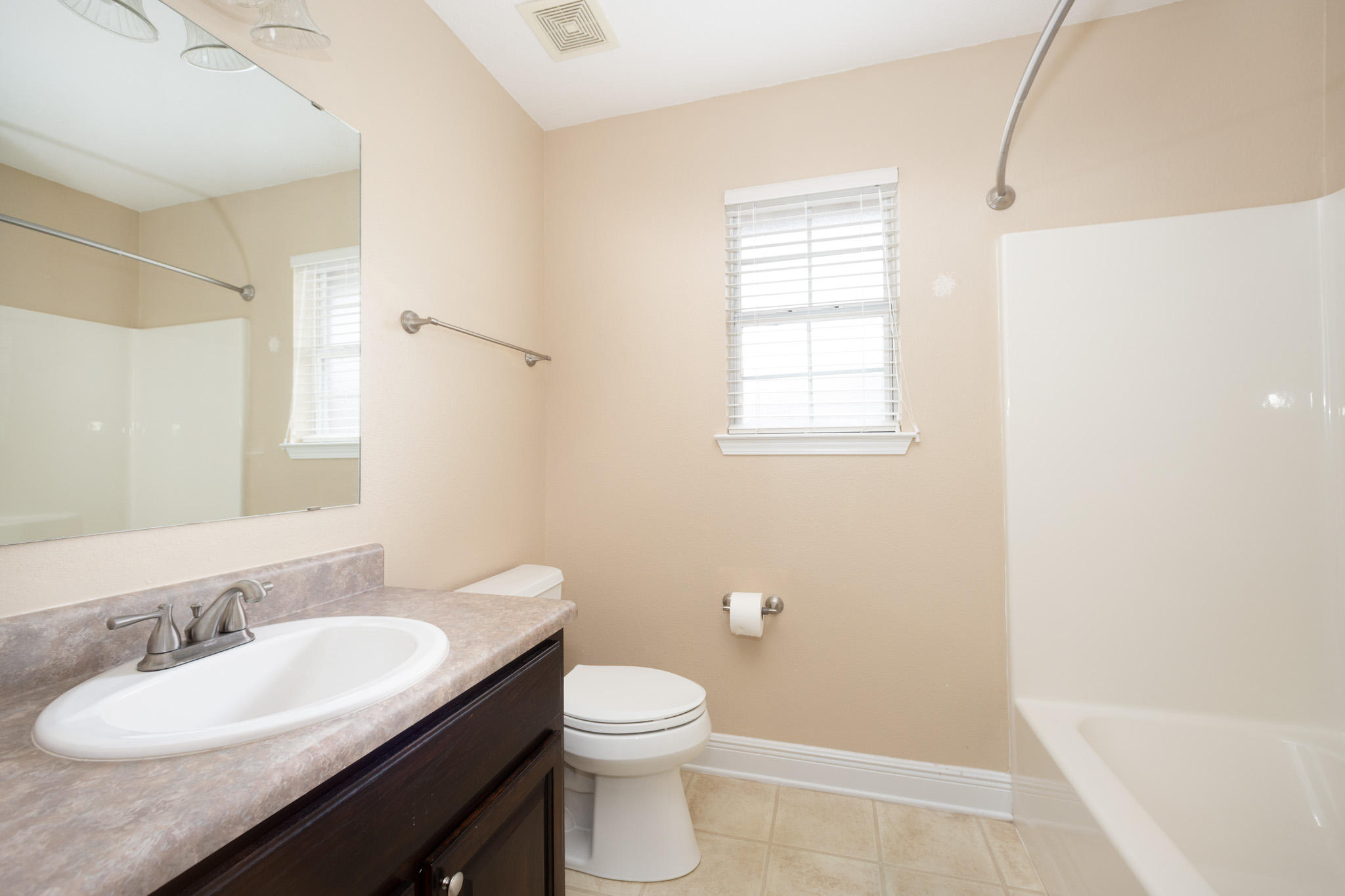 653 Territory Lane Crestview, FL 32536 - Photo 23 of 29 a bathroom with a granite countertop sink toilet a mirror and a tub