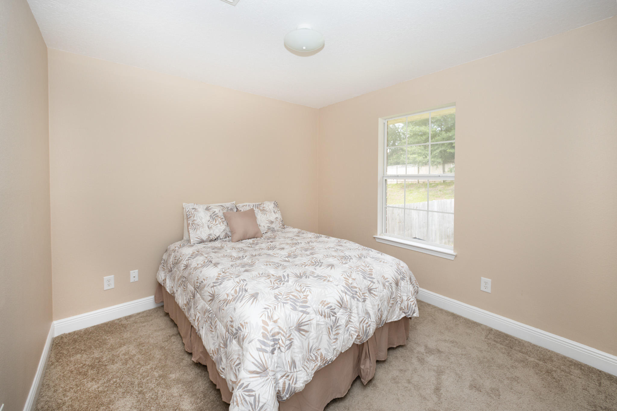 653 Territory Lane Crestview, FL 32536 - Photo 25 of 29 a bed sitting in a bedroom next to a window