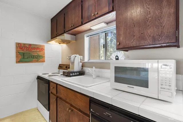 a kitchen with stainless steel appliances wooden cabinets and a stove top oven
