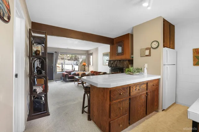 a kitchen with a sink a counter and chairs