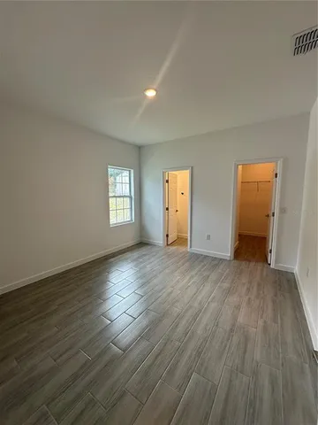 an empty room with wooden floor and window