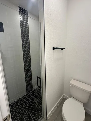 a bathroom with a toilet and a shower