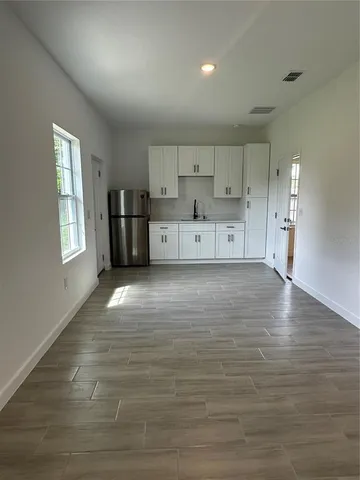 a view of kitchen with wooden floor and cabinets