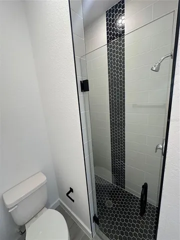 a bathroom with a toilet and a shower