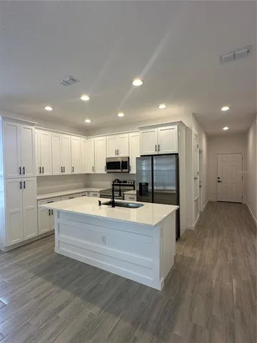a large kitchen with kitchen island a sink and a stove