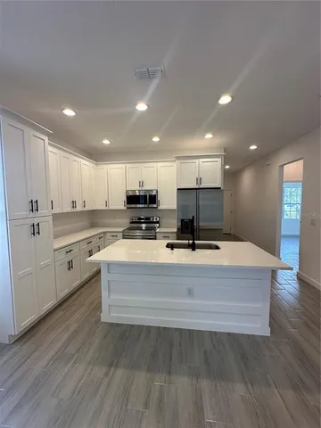 a view of kitchen with sink microwave and refrigerator